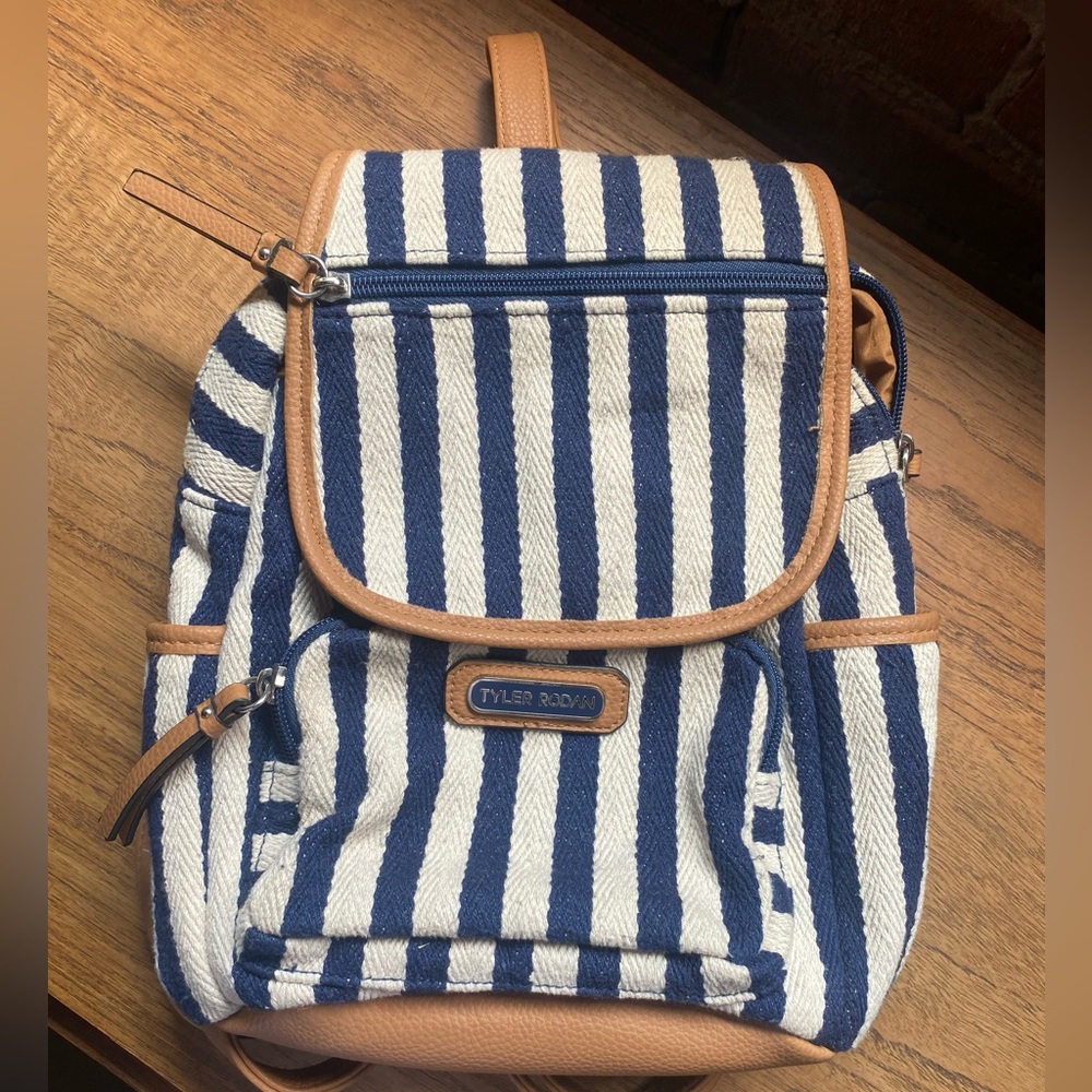 Tyler Rodan blue and white striped small backpack. Brown leather trim details.